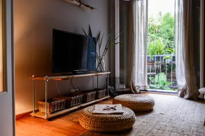 a living room with a flat screen tv and ottoman at Your 