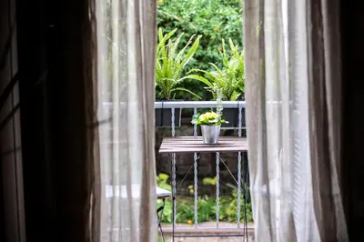 a window with a table with a pot of flowers at Your 