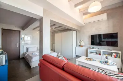 a living room with a red couch and a bedroom at TOP Kolonaki Studio+Terrace Stunning Acropolis Views in Athens