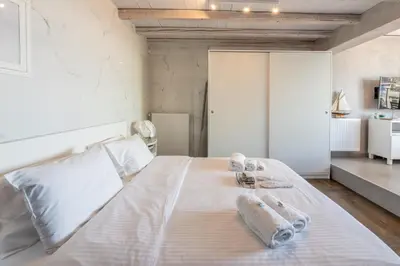 a bedroom with a white bed with towels on it at TOP Kolonaki Studio+Terrace Stunning Acropolis Views in Athens