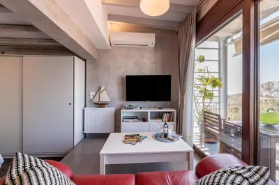 a living room with a couch and a tv at TOP Kolonaki Studio+Terrace Stunning Acropolis Views in Athens