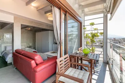 a living room with a red couch and a table at TOP Kolonaki Studio+Terrace Stunning Acropolis Views in Athens