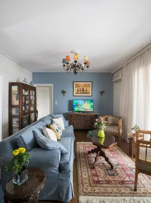 a living room with a blue couch and a tv at Unique Flat with Sea View at Edem Beach - A Seafront Property by Athenian Homes in Athens