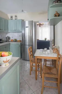 a kitchen with a table and chairs and a refrigerator at Unique Flat with Sea View at Edem Beach - A Seafront Property by Athenian Homes in Athens