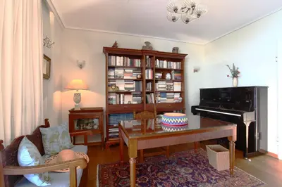 a living room with a piano and a table at Unique Flat with Sea View at Edem Beach - A Seafront Property by Athenian Homes in Athens