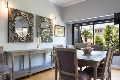 a dining room with a table and chairs and mirrors at Beautiful Penthouse in Athens with outdoor jacuzzi in Athens