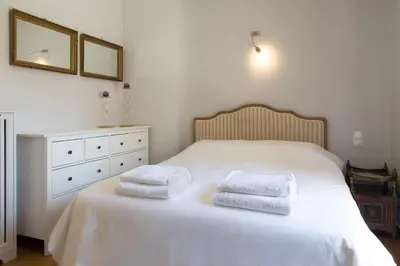 a bedroom with a white bed with two towels on it at Beautiful Penthouse in Athens with outdoor jacuzzi in Athens
