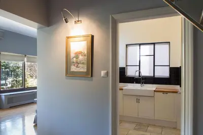 a kitchen with a sink and a painting on the wall at Beautiful Penthouse in Athens with outdoor jacuzzi in Athens