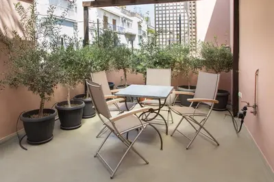 a table and chairs on a balcony with potted plants at Beautiful Penthouse in Athens with outdoor jacuzzi in Athens