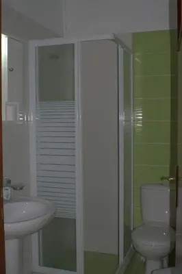 a bathroom with a shower and a toilet and a sink at Nikolaki Rooms in Porto Rafti