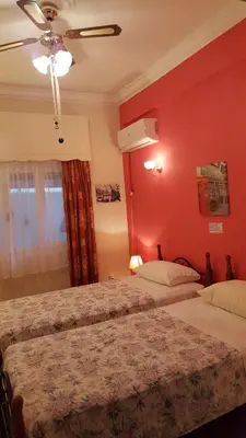 a bedroom with two beds and a red wall at KOKONI APARTMENTS AMBELOKIPI, ATHENS in Athens