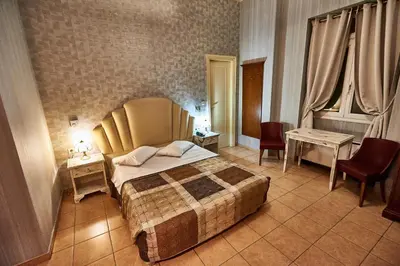 a bedroom with a bed and two tables and chairs at Exis Hotel in Athens