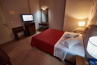 a hotel room with a bed and a television at Exis Hotel in Athens