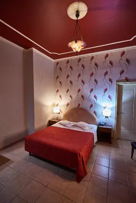 a bedroom with a bed with a red bedspread at Exis Hotel in Athens