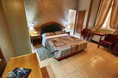 a bedroom with a bed and a table and chairs at Exis Hotel in Athens