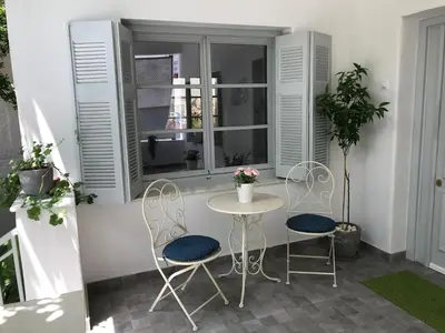 a patio with a table and two chairs and a window at Dina's House in Spáta