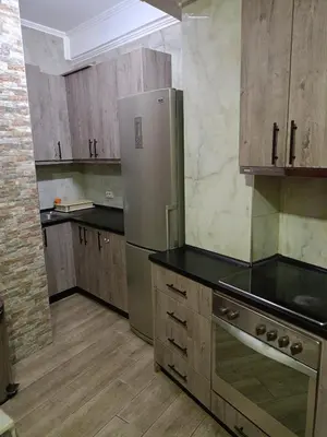 a kitchen with a stainless steel refrigerator and wooden cabinets at Athens Center Cosy Apartment in Athens