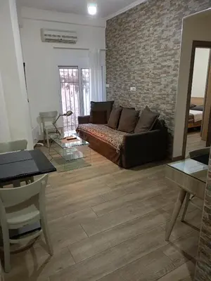 a living room with a couch and a brick wall at Athens Center Cosy Apartment in Athens