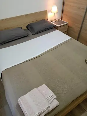 a bedroom with a large bed with two towels on it at Athens Center Cosy Apartment in Athens