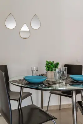 a dining room table with blue plates and chairs at Elvita Apartments 2 in Athens
