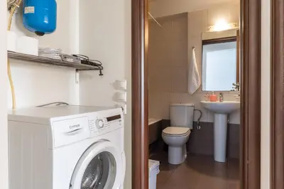 a bathroom with a washing machine and a sink at Elvita Apartments 2 in Athens