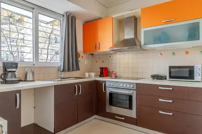 a kitchen with orange cabinets and a stove top oven at Elvita Apartments 2 in Athens