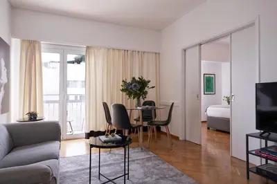 a living room with a table and a bedroom at Parthenon Apartment in Athens