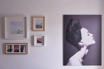 a picture of a woman on a wall with framed pictures at Parthenon Apartment in Athens