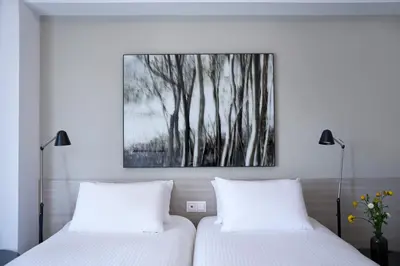 two beds in a bedroom with a picture on the wall at Parthenon Apartment in Athens