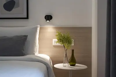 a bedroom with a bed and a table with a vase and a bottle at Parthenon Apartment in Athens