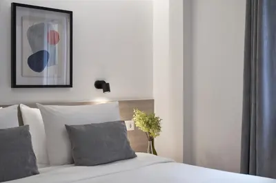 a bedroom with a bed with white sheets and gray pillows at Parthenon Apartment in Athens