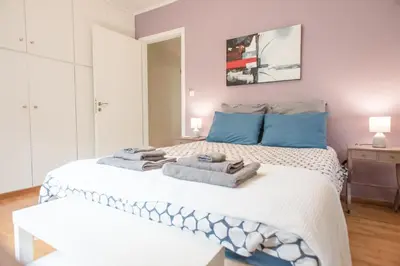 a bedroom with a bed with towels on it at Affordable luxury garden apartment in Athens
