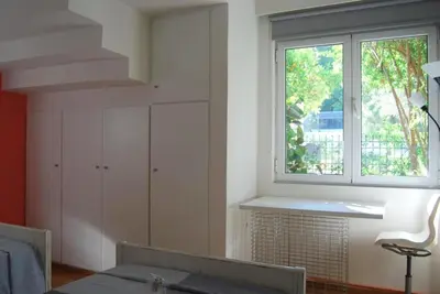 a living room with a window and a table at Affordable luxury garden apartment in Athens