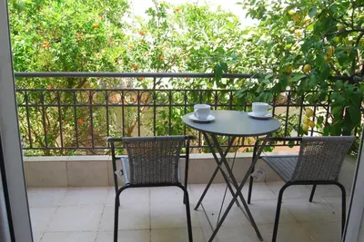 a table and two chairs sitting on a balcony at Affordable luxury garden apartment in Athens