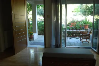 an open door to a patio with a table and chairs at Affordable luxury garden apartment in Athens