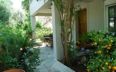 an entrance to a house with an orange tree at Affordable luxury garden apartment in Athens