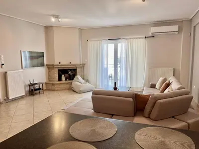 a living room with a couch and a fireplace at Hector Apartment Airport by Airstay in Spáta