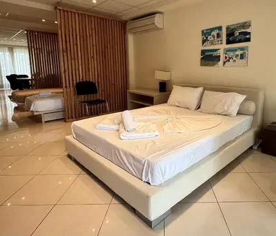 a bedroom with a large bed with towels on it at Hector Apartment Airport by Airstay in Spáta