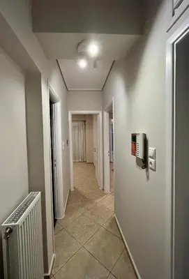 an empty hallway with a radiator in a room at Hector Apartment Airport by Airstay in Spáta