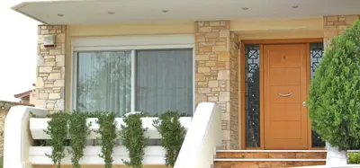 a house with a white fence in front of a door at Hector Apartment Airport by Airstay in Spáta