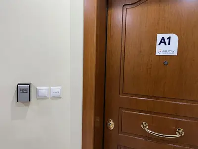 a wooden door with a sign on it next to it at Hector Apartment Airport by Airstay in Spáta