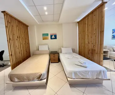 two beds in a room with wooden dividers at Hector Apartment Airport by Airstay in Spáta
