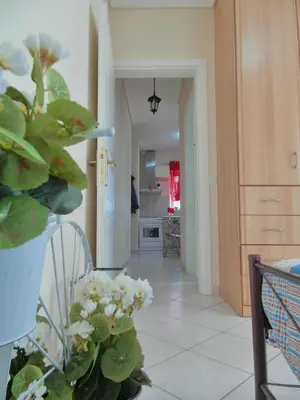 a living room with a potted plant and a hallway at Athens Metro Mall Apart in Athens