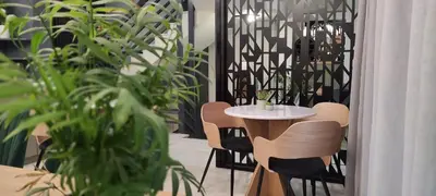 a table and chairs in a room with plants at Be My Guest Athens in Athens