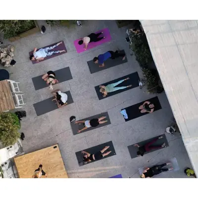 a group of people doing yoga in a courtyard at Be My Guest Athens in Athens
