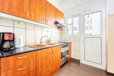 a kitchen with wooden cabinets and a sink at Apartment in the Middle of Everything in Athens