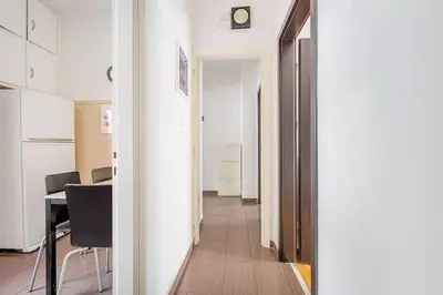 a hallway with a table and a clock on a wall at Apartment in the Middle of Everything in Athens