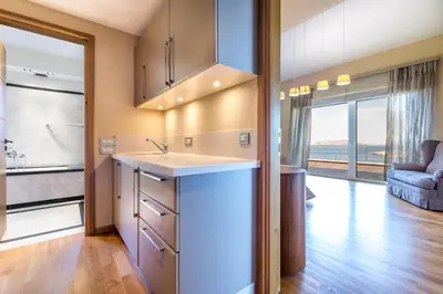 a kitchen with a sink and a living room at Analisa Luxury Villa in Sounio