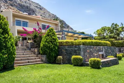 a house with a stone retaining wall and stairs at Analisa Luxury Villa in Sounio