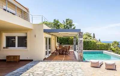 a house with a swimming pool and a patio at Analisa Luxury Villa in Sounio
